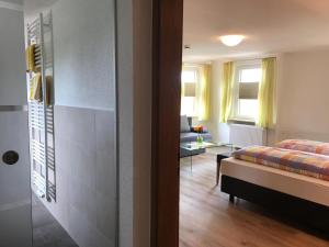 a bedroom with a bed and a living room at Gasthof Rössle Ochsenwang in Bissingen an der Teck