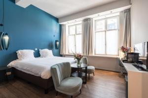 a bedroom with a bed with a blue wall at Zakske13 - Design Boutique B&B in Bruges city centre in Bruges