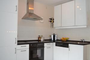 een keuken met witte kasten en een fornuis met oven bij Kurpark Maisonnette Willingen in Willingen