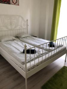 a white bed in a room with a green curtain at Sportarena & Stadion Apartman H-39 in Budapest