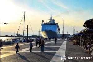 a group of people walking on a pier with a large ship at Anastasis garden room in Kalamata