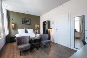 a bedroom with a bed and a table with chairs at Zakske13 - Design Boutique B&B in Bruges city centre in Bruges