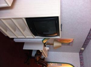 a tv on a shelf in a room at O'Hare Inn & Suites in Schiller Park