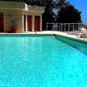 a large pool of blue water in front of a house at La terrazza di monaco in Cap d'Ail