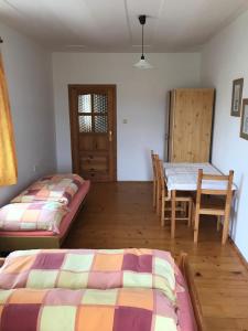 Zimmer mit 2 Betten, einem Tisch und einem Esszimmer in der Unterkunft Samota jak víno in Jihlava