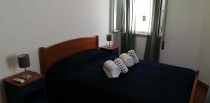 una camera con un letto blu con due cuscini sopra di Casa do canto a Tavira