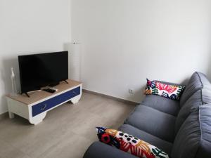 un soggiorno con divano e TV a schermo piatto di Casa do canto a Tavira