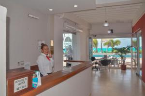 聖安德烈斯的住宿－波多貝洛海灘酒店，站在海滩房间柜台上的人