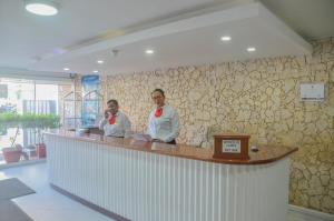 two people standing at a counter in a restaurant at Hotel Portobelo Convention Center in San Andrés