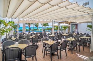 サン・アンドレスにあるPortobelo Beachの海とテーブルと椅子が備わるレストラン