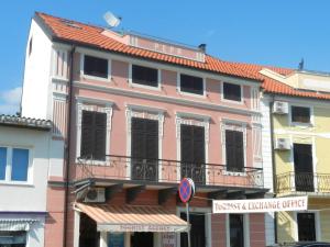 a pink building with a balcony on a street at Apartments Jozefina in Crikvenica