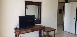 een televisie op een tafel voor een spiegel bij Executive Apartment Guatemala City in Guatemala