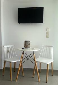 two white chairs and a table and a tv at Casa del Mare in Vlikhon