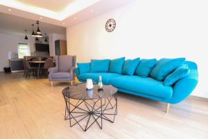 a living room with a blue couch and a table at Brand New Apartment in Malinska in Malinska