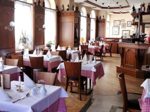 a restaurant with tables and chairs with white tablecloths at Hotel DREI SCHWANEN - Ristorante Due Fratelli in Hohenstein-Ernstthal