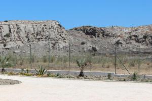 a fence in the middle of a desert with a mountain at B&B L'EDEN DI CAPO BIANCO in Montallegro