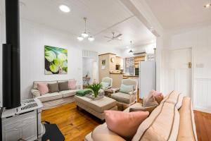 a living room with a couch and a tv at Frangipani House in Toowoomba