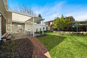 a backyard with a patio and a lawn at Frangipani House in Toowoomba