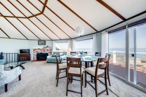 ein Wohnzimmer mit einem Tisch, Stühlen und Meerblick in der Unterkunft A Whale of a View! in Depoe Bay