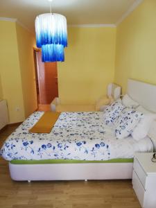 a bedroom with a bed with blue and white sheets at Apartamento Alcazar in Melide