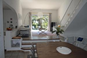 a living room with a table and a staircase at Villa Hortense - Golf of Saint Tropez in Sainte-Maxime
