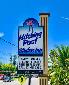 a sign for a hitting post stands in a parking lot at Hitching Post Studios Inn in Santa Cruz
