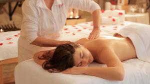 une femme dans un salon de spa recevant une ahapsophen dans l'établissement Villa Campomaggio Resort & SPA, à Radda in Chianti