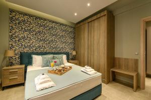 a bedroom with a large bed with towels on it at Sunny Luxury Suite Grey in Kavála