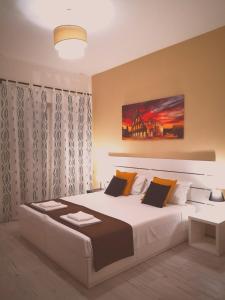 ein Schlafzimmer mit einem großen weißen Bett mit orangefarbenen Kissen in der Unterkunft The Royals in Rom