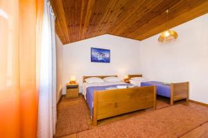 - une chambre avec deux lits et un plafond en bois dans l'établissement Apartment Matkos - with garden and terrace, à Nin