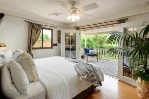 a bedroom with a large bed and a balcony at Paia Inn in Paia
