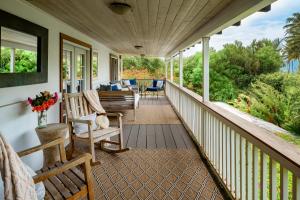 a porch with rocking chairs and a couch at Paia Inn in Paia