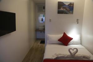 Un dormitorio con una cama con dos corazones. en Mayumi Lodge en Puerto Princesa