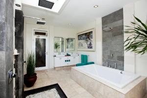 a bathroom with a large tub and a sink at Puri Mas Boutique Resort & Spa in Senggigi
