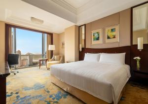 pokój hotelowy z łóżkiem i dużym oknem w obiekcie Shangri-La Suzhou w mieście Suzhou