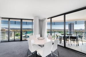 uma sala de jantar com uma mesa e cadeiras brancas em Peppers Broadbeach em Gold Coast