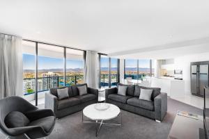 a living room with two couches and a table at Peppers Broadbeach in Gold Coast