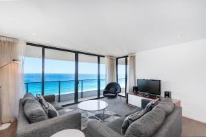 Sala de estar con 2 sofás y TV en Peppers Broadbeach, en Gold Coast