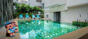 a swimming pool with two dolls sitting next to it at The BluEco Hotel SHA Plus in Kata Beach