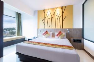 a bedroom with a large bed and a large window at The BluEco Hotel SHA Plus in Kata Beach +53 photos