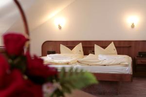 two beds in a hotel room with white pillows at Rennsteighotel Herrnberger Hof in Neuhaus am Rennweg