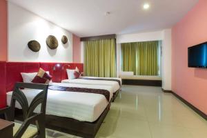 a hotel room with two beds and a flat screen tv at The BluEco Hotel SHA Plus in Kata Beach