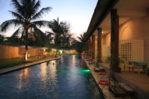 a swimming pool with lights in the middle of a house at Wild Orchid Beach Resort in Olongapo