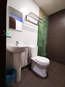 e bagno con servizi igienici, lavandino e doccia. di D'Green Hotel Kuching a Kuching
