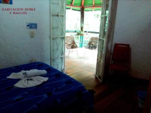 um quarto com uma cama e uma porta para um pátio em La Posada del Cucú em Salento