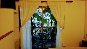 a room with curtains and a table on a balcony at Cabañas Te Maori in Hanga Roa