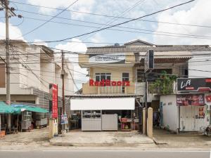 a building with a sign on the side of a street at RedDoorz at Tara Homestay Palembang in Palembang