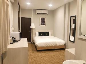 a hotel room with a bed and a television at GN Luxury Hostel in Bangkok