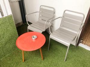 a red chair sitting on top of a green lawn at GN Luxury Hostel in Bangkok