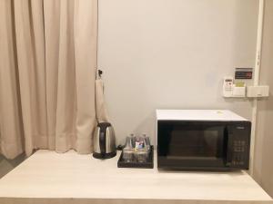a kitchen with a microwave and a coffee maker at GN Luxury Hostel in Bangkok